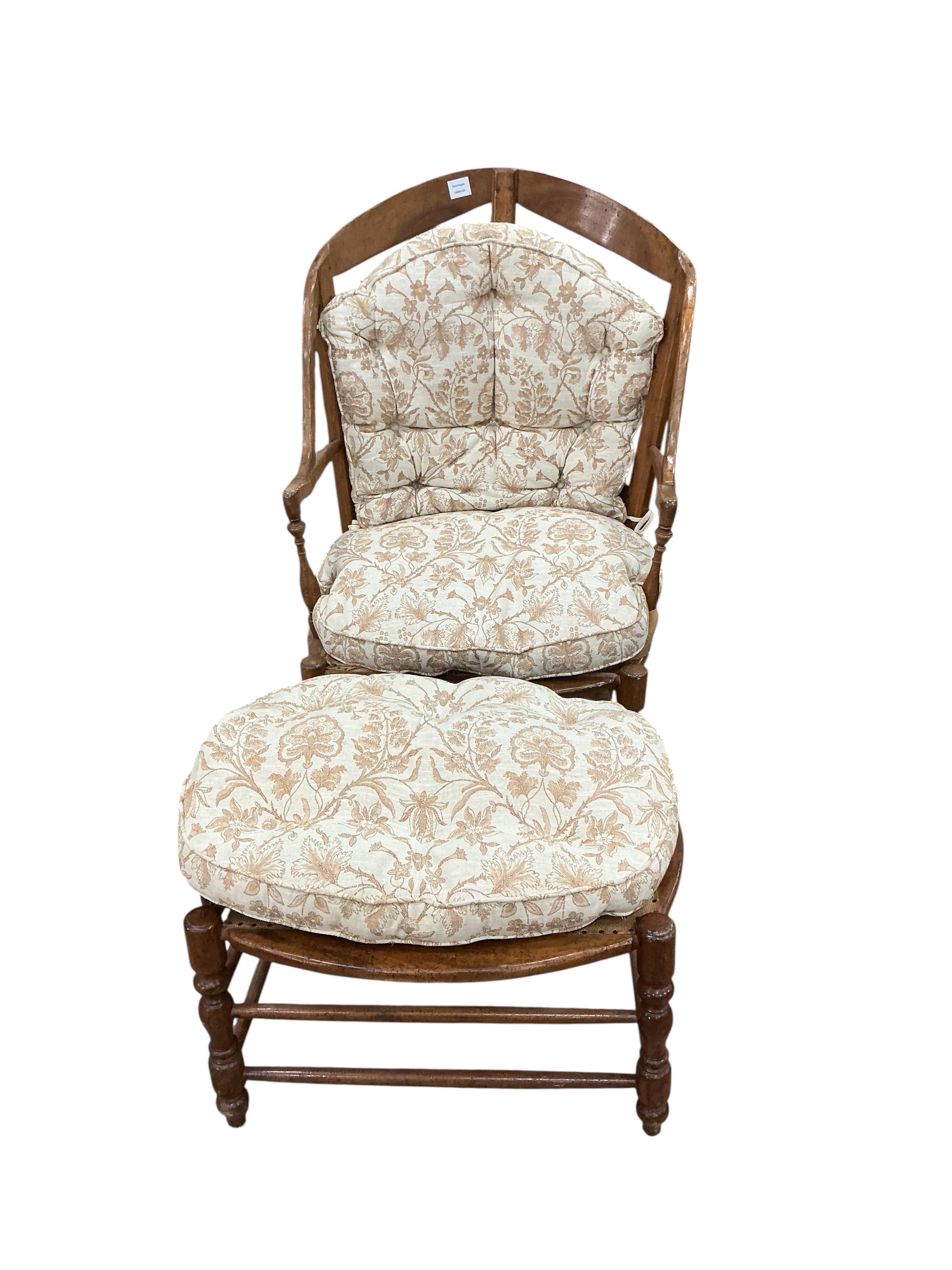A 19th century French fruitwood armchair, width 70cm, depth 64cm, height 112cm and foot stool